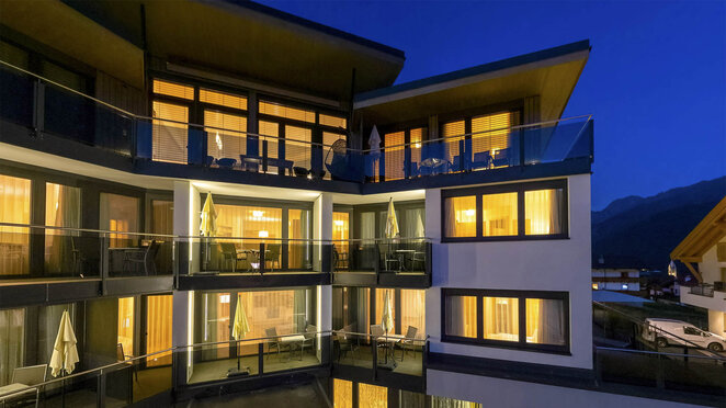 Berglife Appartements in Serfaus am Abend mit beleuchteten Fenstern und Balkonen