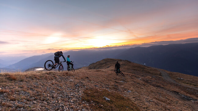 Mountainbiker genießen den Sonnenaufgang auf einem Bergrücken
