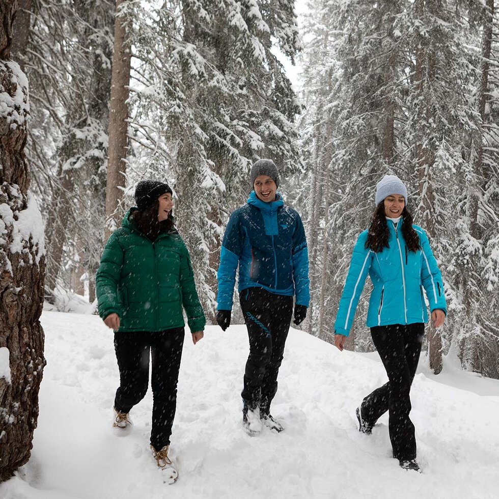 Personen wandern auf dem winterlichen Besinnungsweg durch den Wald